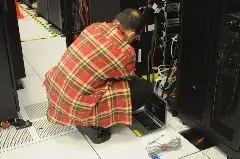 Техник у серверной стойки в дата-центре NERSC. Фото: Derrick Coetzee, CC0